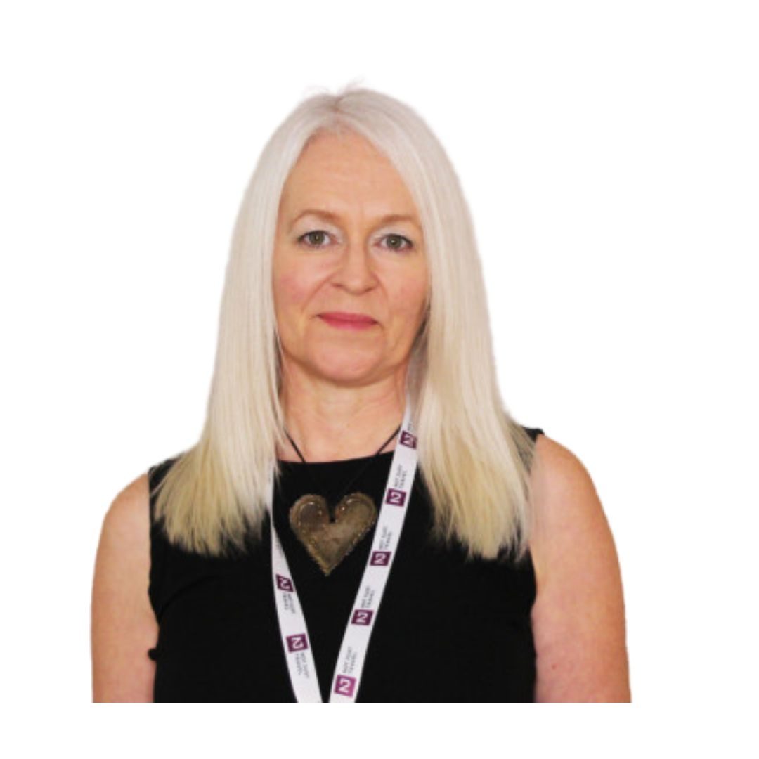 Photo of Samantha Green of Not Just Travel wearing a sleeveless black top and a heart shaped large metal necklace. She also has a lanyard with NJT logo on it. She has white blonde shoulder length hair. 